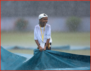 A young Test Match helper doesn't mind the rain, Dhaka, Bangladesh.