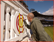 Painting the carved players gates outside the pavilion