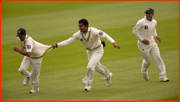 Yasir Hameed is grabbed by Umar Akmal after catching Jonathan Trott.